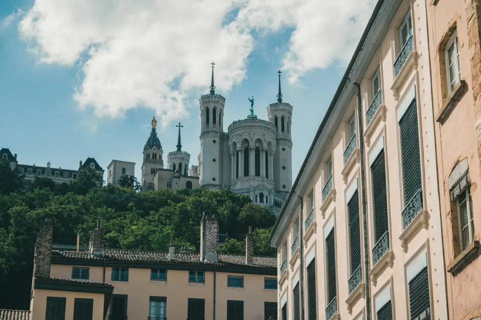 A view of a city with a church on a hill in the background